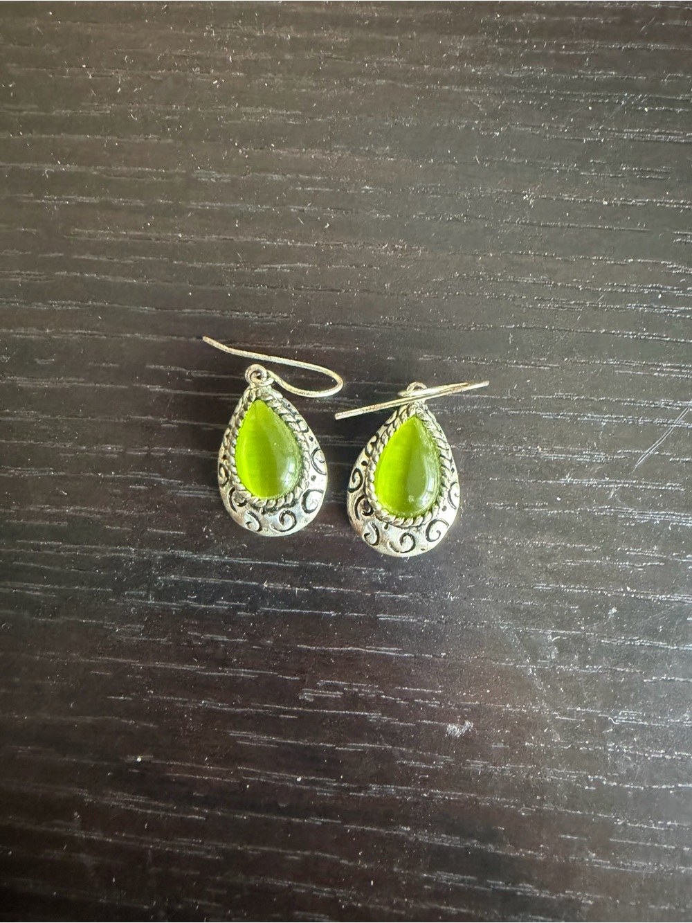 Silver-toned dangle earrings featuring a translucent light-green stone.